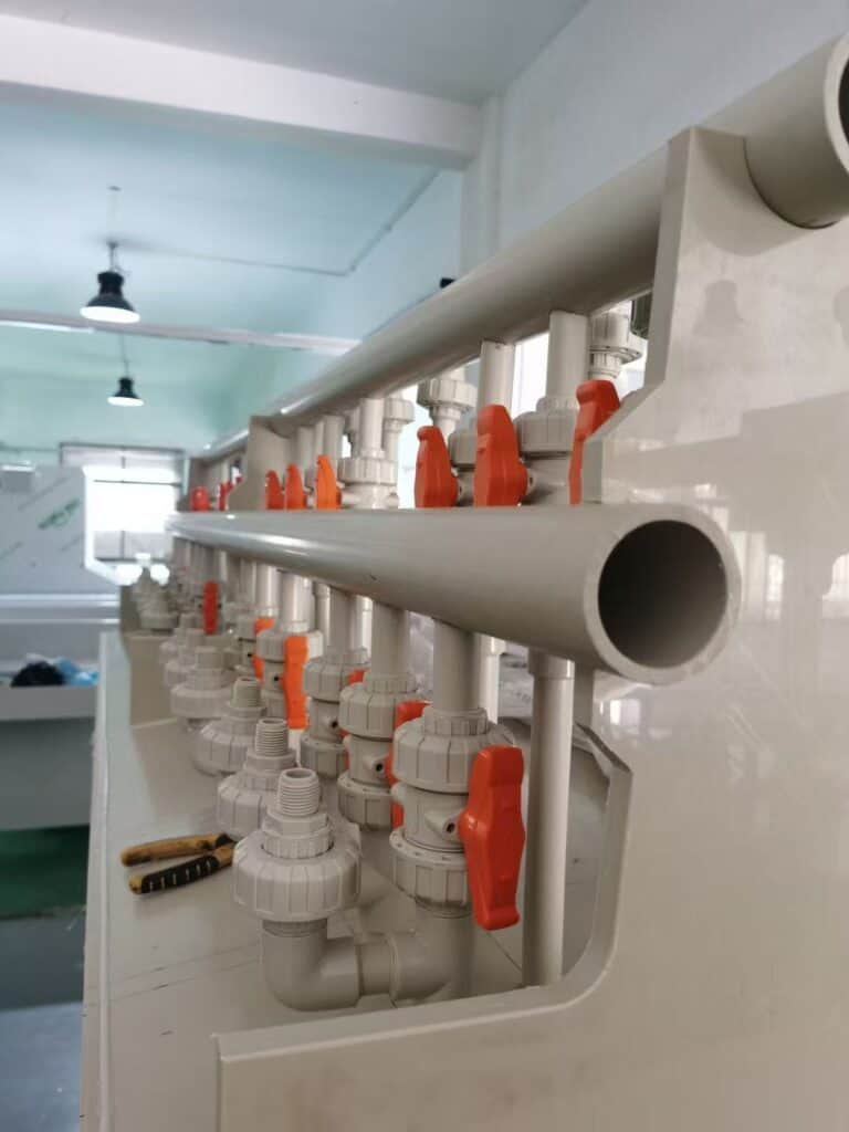 Industrial PPH piping system and manifold featuring multiple PPH manual true union ball valves with orange handles installed on a chemical dosing skid